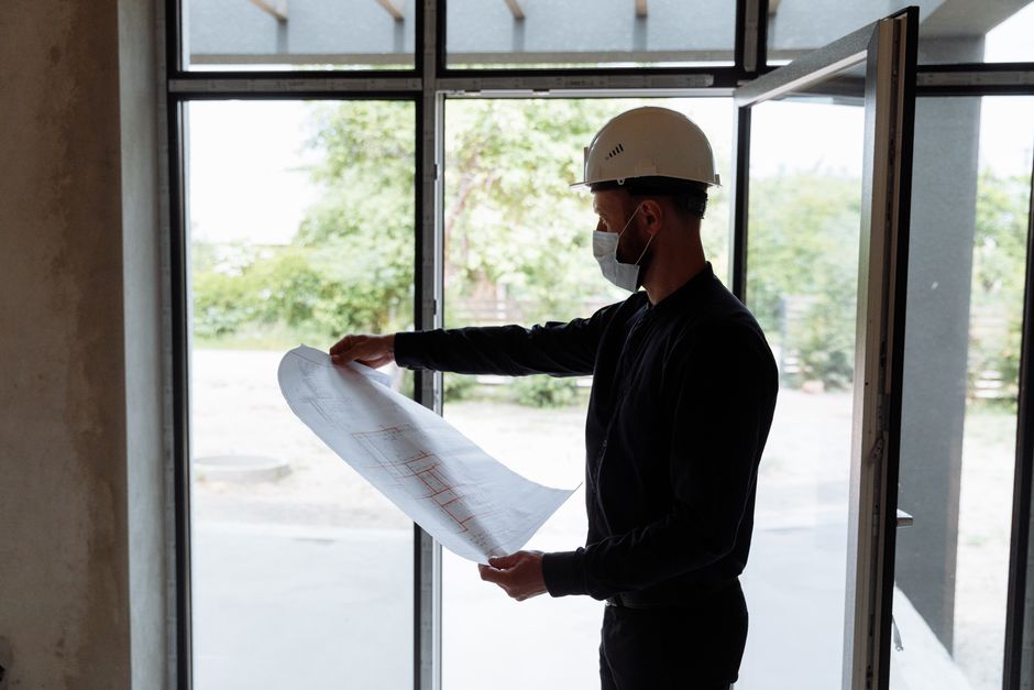 General contractor reviewing architectural blueprints on site
